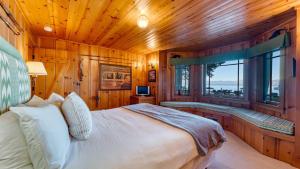 a bedroom with a large bed and a window at Homewood Lakefront by AvantStay Private Beach Lake Access Views in Homewood