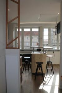 a kitchen with two stools and a counter and some windows at Appartement Cosy avec Sauna - Angouleme - 4 personnes in Angoulême