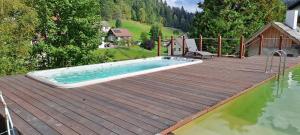 a swimming pool on a wooden deck next to a house at Ferienhaus Enzquelle in Enzklösterle