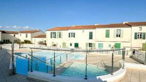 a swimming pool in front of a building at Jolie maison à étage en résidence avec piscine in Saint-Martin-de-Ré