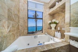 une salle de bain avec une baignoire et une fenêtre et l'océan dans l'établissement Ocean Vista Penthouse 2, à San Diego 17 autres photos