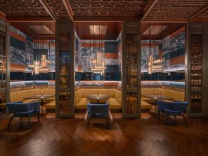 a restaurant with tables and chairs in a room at Sofitel Bangkok Sukhumvit in Bangkok
