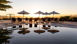 a reflection of chairs and umbrellas in a pool of water at Pezula Nature Retreat in Knysna