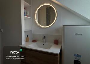 a bathroom with a sink and a mirror at L'escale - charmant studio à Laval in Laval