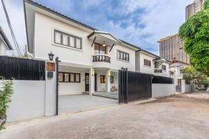 a white house with a gate and a fence at Luxury Pool Villa Jomtien-1 Min to Beach in Jomtien Beach
