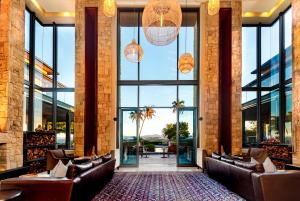a lobby with leather chairs and large windows at Pezula Nature Retreat in Knysna