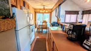 a kitchen with a refrigerator and a dining room at Frost Hollow by AvantStay Deck w Grill Game Room Loft in White Haven