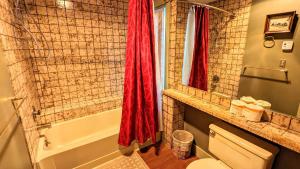 a bathroom with a red shower curtain and a toilet at Frost Hollow by AvantStay Deck w Grill Game Room Loft in White Haven +14 photos