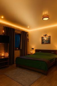a bedroom with a green bed and a television at Shatiz in Izki