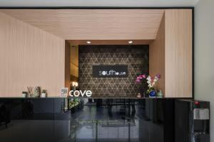 a lobby with a counter with a sign that reads cure at Cove Southouse Residence in Jakarta