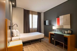 a hotel room with a bed and a desk at Eurostars Indautxu in Bilbao