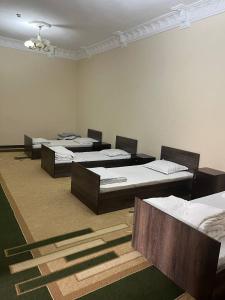 a room with four beds in a row in a room at ZARIN Guest house in Bukhara +4 photos