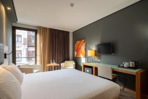 a hotel room with a bed and a desk at Eurostars Indautxu in Bilbao