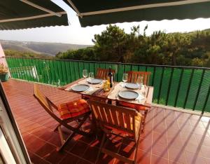a wooden table with four chairs on a patio at Granny's House by Trip2Portugal in Carvoeira