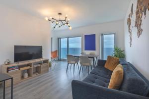 a living room with a couch and a tv and a table at A-MO Sesimbra by Trip2Portugal in Sesimbra