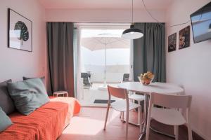 a living room with a couch and a table with chairs at Amazing Sesimbra Duplex by the beach in Sesimbra