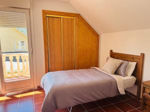 a bedroom with a bed with a wooden headboard and a window at Casa rústica en paraje natural in El Espinar
