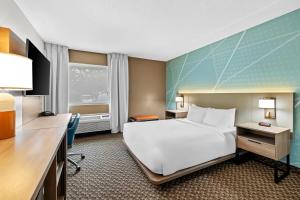 トラバースシティにあるComfort Inn Traverse Cityの大きなベッドと机があるホテルの部屋
