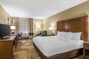 una camera d'albergo con un letto grande e una scrivania di Comfort Inn Sedalia Station a Sedalia Altre 46 foto