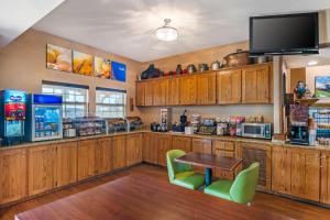 una cucina con armadi in legno, tavolo e TV di Comfort Inn Sedalia Station a Sedalia