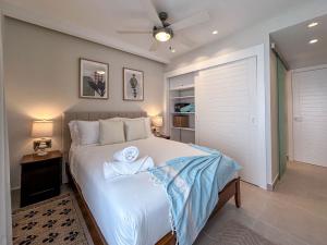 a bedroom with a bed with two towels on it at Beautiful brand new Beach Condo w Picuzzi in Punta Cana +46 photos