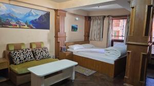 Habitación pequeña con 2 camas y sofá en Moon Light Guest House, en Bhaktapur