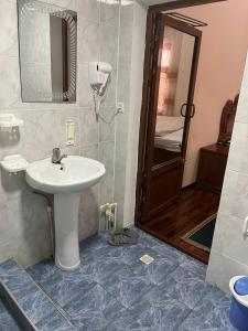 a bathroom with a sink and a mirror at ZARIN Guest house in Bukhara