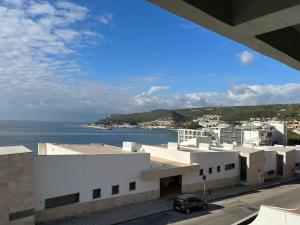 a view of a building with the ocean in the background at Amazing Sesimbra Duplex by the beach in Sesimbra