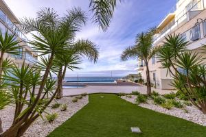 a courtyard with palm trees in front of a building at A-MO Sesimbra by Trip2Portugal in Sesimbra