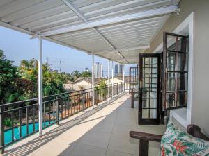 a balcony of a house with awning and a bench at Oyster Tide Self-Catering & B and B in Durban