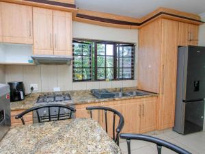 a kitchen with wooden cabinets and a counter top at Oyster Tide Self-Catering & B and B in Durban