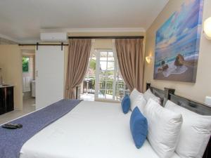 a bedroom with a large white bed with blue pillows at Oyster Tide Self-Catering & B and B in Durban