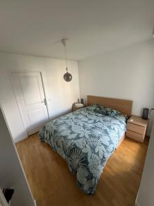 ein Schlafzimmer mit einem Bett mit einer blau-weißen Decke in der Unterkunft Appartement proche centre d'affaires calme et terrasse in Issy-les-Moulineaux