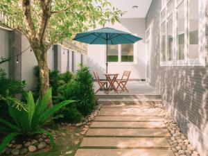 un patio avec une table et un parasol dans l'établissement Amory Sea View Pool Villa - 5 Bedrooms, à Mui Ne