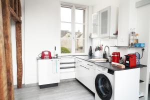 a white kitchen with a washing machine in it at Trio Cathédrale in Chartres +16 photos