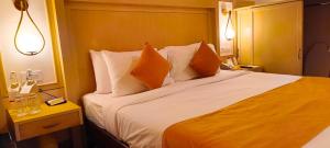 Un dormitorio con una cama grande con almohadas naranjas. en Ira Navi Mumbai, en Kālaj