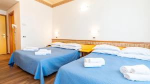 Una habitación con tres camas con toallas. en Hotel Cosmopol Cesenatico, en Cesenatico 30 fotos más