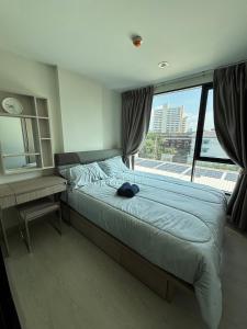 a bedroom with a bed and a desk and a window at Sukhumvit 50 apartment in Bangkok