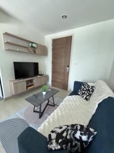 a living room with a couch and a tv at Sukhumvit 50 apartment in Bangkok