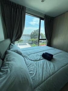 a large bed in a room with a large window at Sukhumvit 50 apartment in Bangkok +8 photos