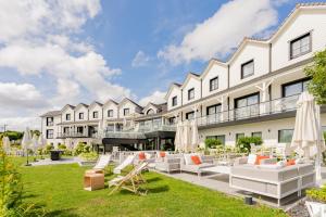 an exterior view of the resort with lounge chairs and umbrellas at Best Western Plus Le Fairway Hotel & Spa Golf d'Arras in Anzin-Saint-Aubin