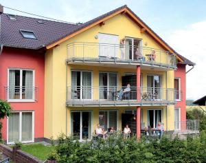 people sitting on the balcony of a house at Ferien im Maigen in Mettlach