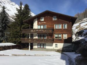 a large wooden building with a balcony in the snow at Cresta di Saas in Saas-Grund