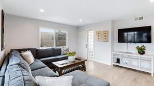 a living room with a couch and a tv at Shelly by AvantStay Steps to the Beach Deck w Ocean Views 5BDR in Newport Beach