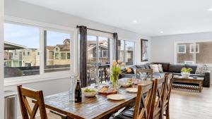 a dining room with a table and a couch at Shelly by AvantStay Steps to the Beach Deck w Ocean Views 5BDR in Newport Beach