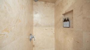 a bathroom with a shower with three bottles of wine at Shelly by AvantStay Steps to the Beach Deck w Ocean Views 5BDR in Newport Beach +21 photos