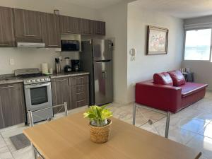 a kitchen with a table and a couch in a room at Brisa Marina Departamento con Alberca y Playa in Boca del Río