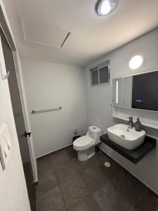 a bathroom with a white toilet and a sink at Brisa Marina Departamento con Alberca y Playa in Boca del Río