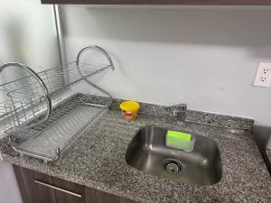 a kitchen counter with a sink and a wire basket at Brisa Marina Departamento con Alberca y Playa in Boca del Río +26 photos