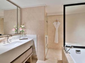 a bathroom with a sink and a shower with a mirror at Hotel The Grand Olive Aero Suites Near Delhi Airport in New Delhi